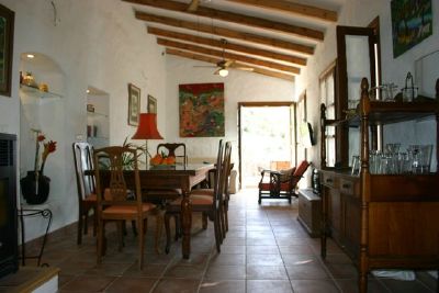 A long view of the sitting and dining rooms emphasising the wood beam ceiling.