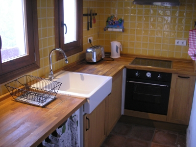 Closer view of the main kitchen work area showing large country style porcelain sink.