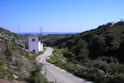 Blick hinunter durch das Tal und die Obstplantagen auf das Meer.