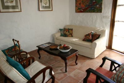 The sitting room with three seater sofa and two antique armchairs.